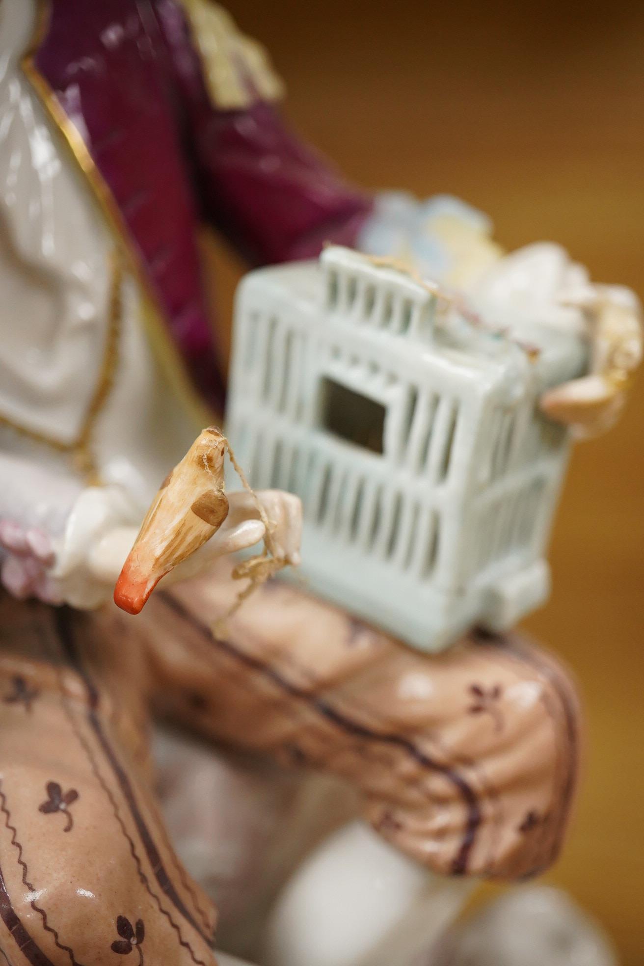 A German porcelain group of two figures with a bird cage and dog, 24cm high (Restored)